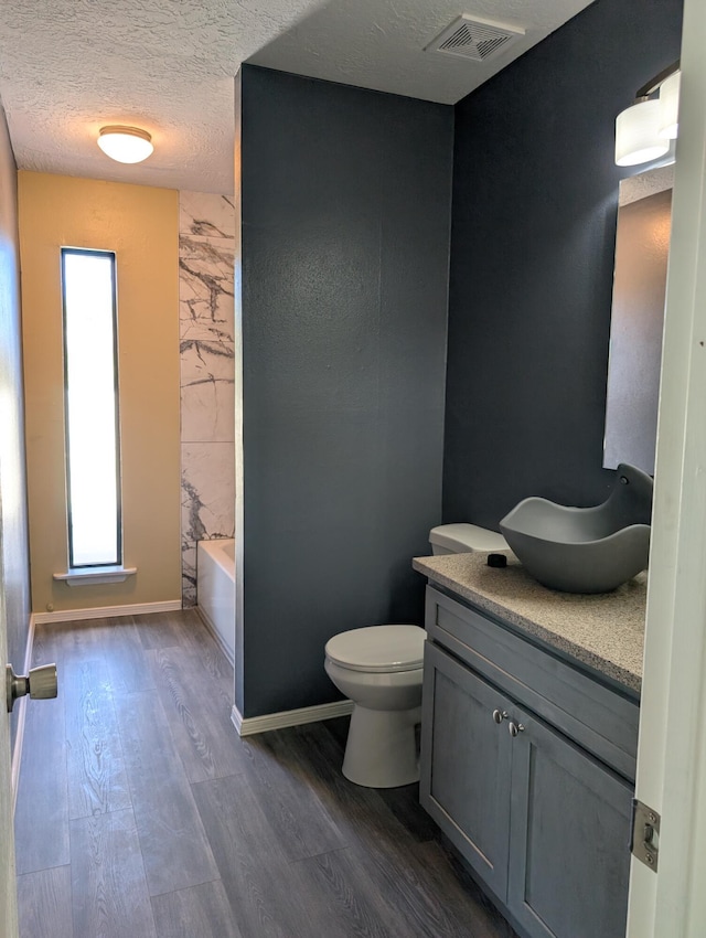 301 Stagecoach Dr, Elephant Butte, NM 87935 - bathroom featuring vanity, wood finished floors, toilet, and a textured ceiling
