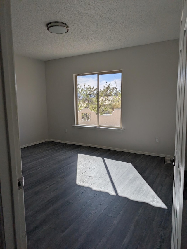301 Stagecoach Dr, Elephant Butte, NM 87935 - empty room featuring dark wood finished floors, baseboards, and a textured ceiling