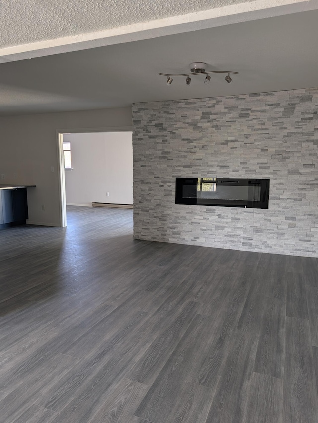 301 Stagecoach Dr, Elephant Butte, NM 87935 - unfurnished living room with a glass covered fireplace, wood finished floors, baseboard heating, and track lighting