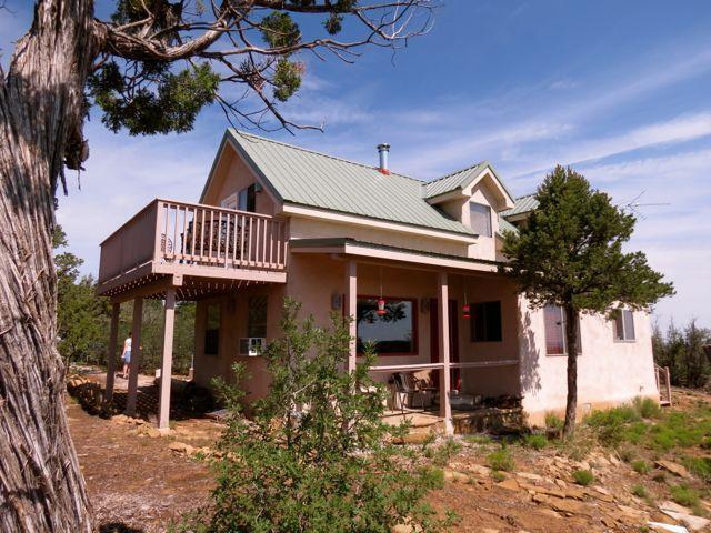 403 Candy Kitchen Rd, Ramah, NM 87321 - view of front of house with stucco siding, a deck, and metal roof