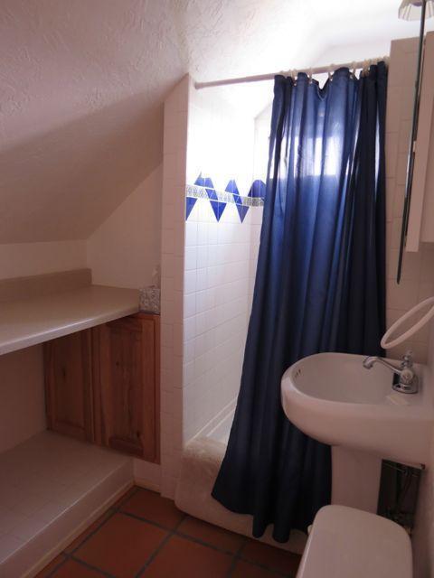 403 Candy Kitchen Rd, Ramah, NM 87321 - full bathroom featuring tile patterned flooring, a shower with curtain, lofted ceiling, toilet, and a textured ceiling