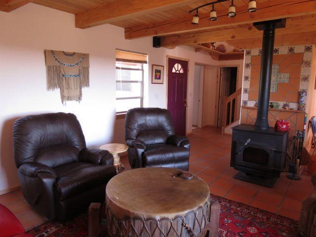 403 Candy Kitchen Rd, Ramah, NM 87321 - tiled living area featuring a wood stove and wooden ceiling with exposed beams