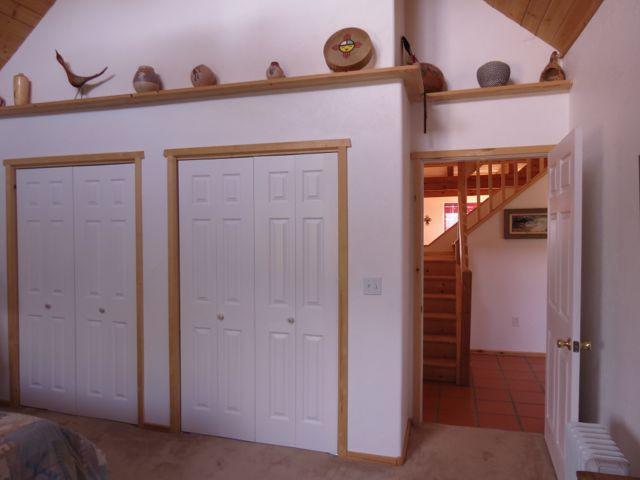403 Candy Kitchen Rd, Ramah, NM 87321 - bedroom featuring radiator, multiple closets, and vaulted ceiling
