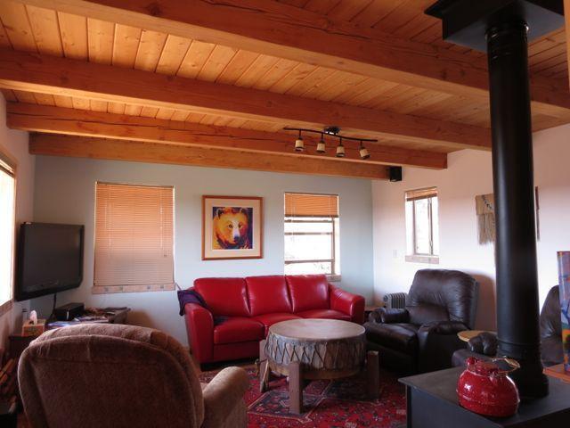 403 Candy Kitchen Rd, Ramah, NM 87321 - living area featuring wooden ceiling with exposed beams and a wood stove
