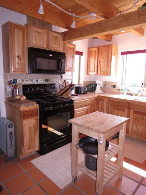 403 Candy Kitchen Rd, Ramah, NM 87321 - kitchen with black appliances, wood ceiling with exposed beams, radiator, decorative backsplash, and light brown cabinets