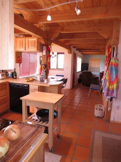 403 Candy Kitchen Rd, Ramah, NM 87321 - kitchen with black dishwasher, wood ceiling with exposed beams, light brown cabinets, light tile patterned floors, and open floor plan