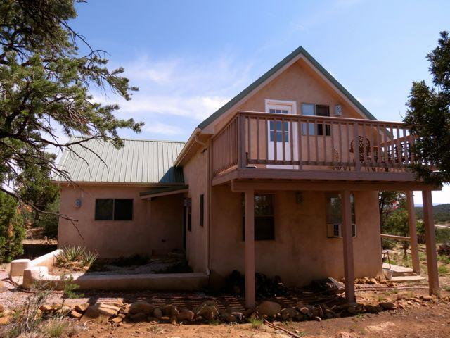 403 Candy Kitchen Rd, Ramah, NM 87321 - rear view of house with a wooden deck, stucco siding, and metal roof