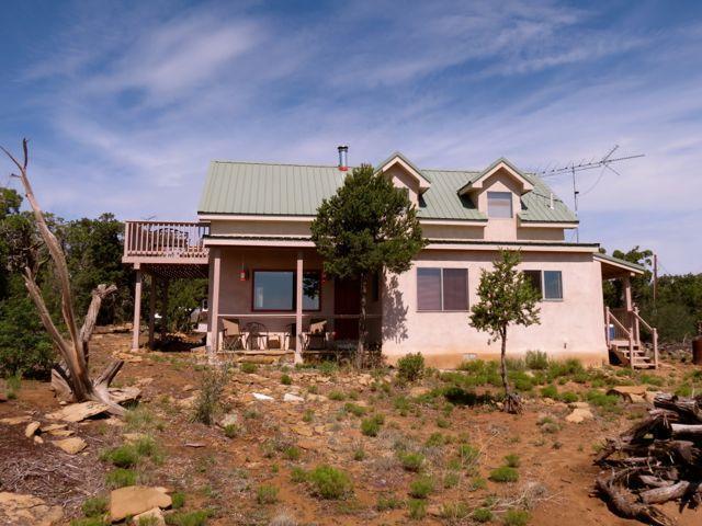 403 Candy Kitchen Rd, Ramah, NM 87321 - view of front facade with stucco siding, a porch, and metal roof