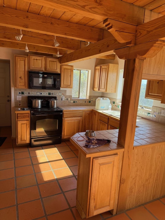 403 Candy Kitchen Rd, Ramah, NM 87321 - kitchen featuring black appliances, tile counters, backsplash, wood ceiling with exposed beams, and tile patterned floors