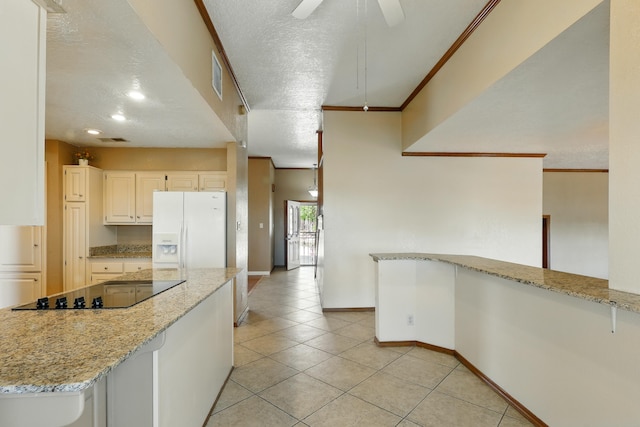 1551 Valley View Dr SW, Los Lunas, NM 87031 - kitchen featuring white refrigerator with ice dispenser, light tile patterned floors, light stone counters, black electric stovetop, and baseboards