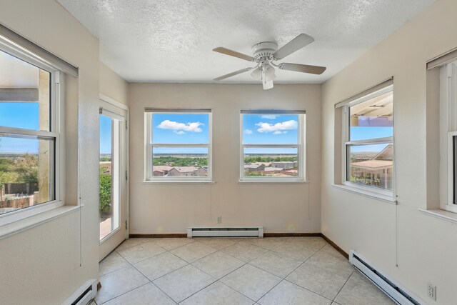 1551 Valley View Dr SW, Los Lunas, NM 87031 - spare room featuring a baseboard heating unit, arched walkways, plenty of natural light, a textured ceiling, and light tile patterned floors