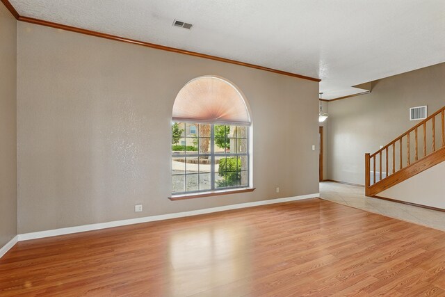1551 Valley View Dr SW, Los Lunas, NM 87031 - spare room with ornamental molding, a ceiling fan, light wood-type flooring, baseboards, and a textured wall