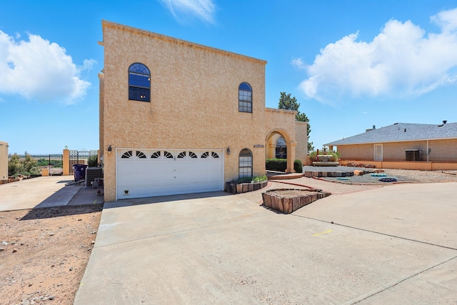 1551 Valley View Dr SW, Los Lunas, NM 87031 - view of side of home featuring a garage, stucco siding, and concrete driveway