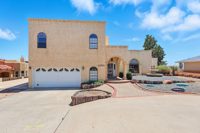 1551 Valley View Dr SW, Los Lunas, NM 87031 - mediterranean / spanish-style home featuring stucco siding, an attached garage, and driveway