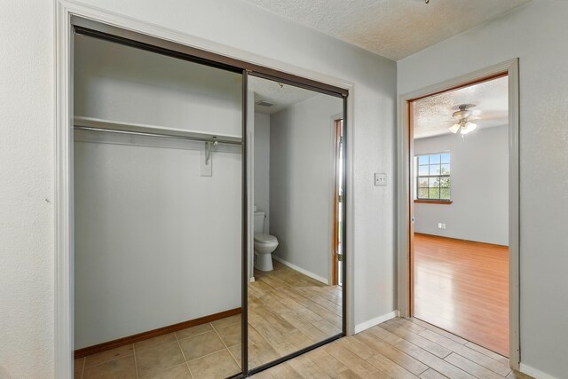 1551 Valley View Dr SW, Los Lunas, NM 87031 - hallway with light wood-style flooring, a textured ceiling, a textured wall, and baseboards