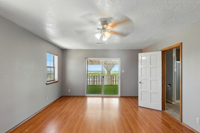 1551 Valley View Dr SW, Los Lunas, NM 87031 - unfurnished room with ceiling fan, healthy amount of natural light, light wood-type flooring, a textured ceiling, and baseboards