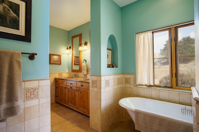 25 Camino Manzano, Placitas, NM 87043 - full bath featuring tile walls, wainscoting, plenty of natural light, a freestanding bath, and vanity