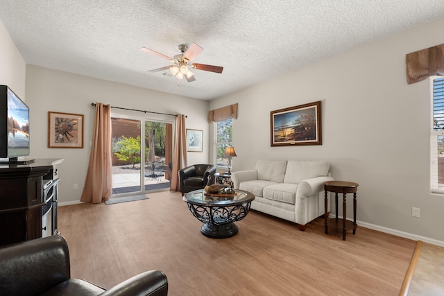 429 Paseo Vista Loop NE, Rio Rancho, NM 87124 - living room with light wood finished floors, ceiling fan, a textured ceiling, and baseboards