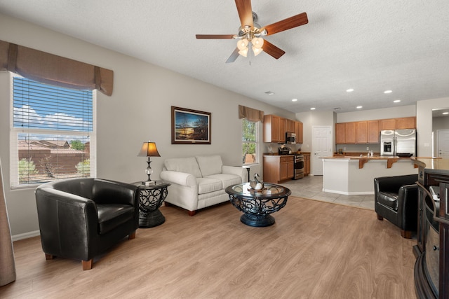 429 Paseo Vista Loop NE, Rio Rancho, NM 87124 - living area with light wood-style floors, a textured ceiling, ceiling fan, recessed lighting, and baseboards
