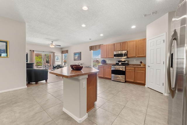 429 Paseo Vista Loop NE, Rio Rancho, NM 87124 - kitchen with appliances with stainless steel finishes, a textured ceiling, open floor plan, light tile patterned floors, and recessed lighting