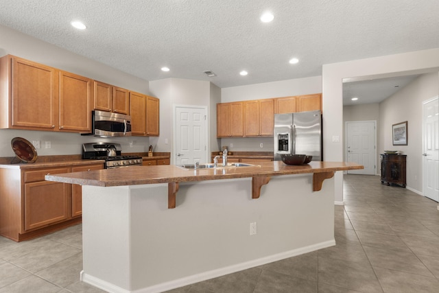 429 Paseo Vista Loop NE, Rio Rancho, NM 87124 - kitchen with stainless steel appliances, a sink, a breakfast bar area, light tile patterned floors, and recessed lighting