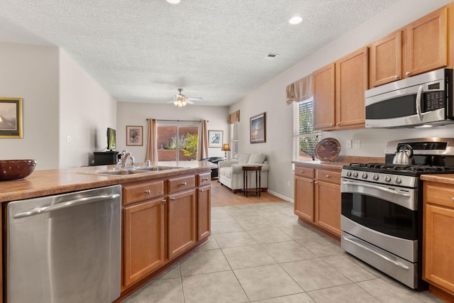 429 Paseo Vista Loop NE, Rio Rancho, NM 87124 - kitchen featuring stainless steel appliances, a sink, healthy amount of natural light, a textured ceiling, and open floor plan