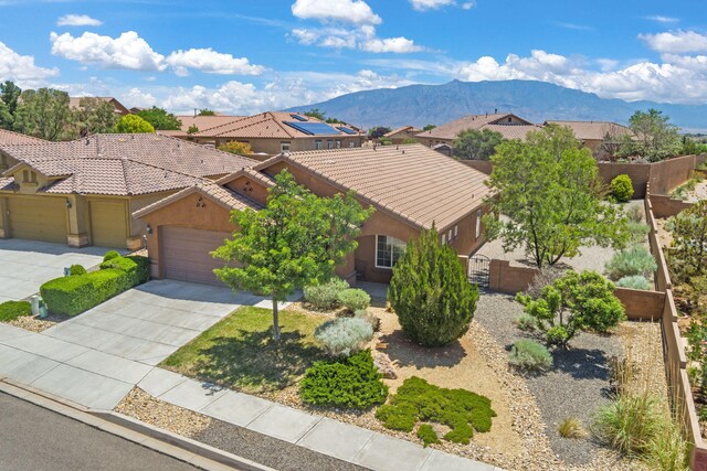 429 Paseo Vista Loop NE, Rio Rancho, NM 87124 - view of front of house with stucco siding, a mountain view, a tile roof, concrete driveway, and an attached garage