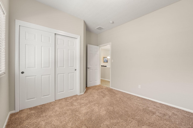 429 Paseo Vista Loop NE, Rio Rancho, NM 87124 - unfurnished bedroom featuring light carpet, a closet, and baseboards