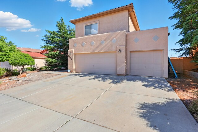 10016 Rio Canon Ave SW, Albuquerque, NM 87121 - view of front of property featuring stucco siding, driveway, and a garage
