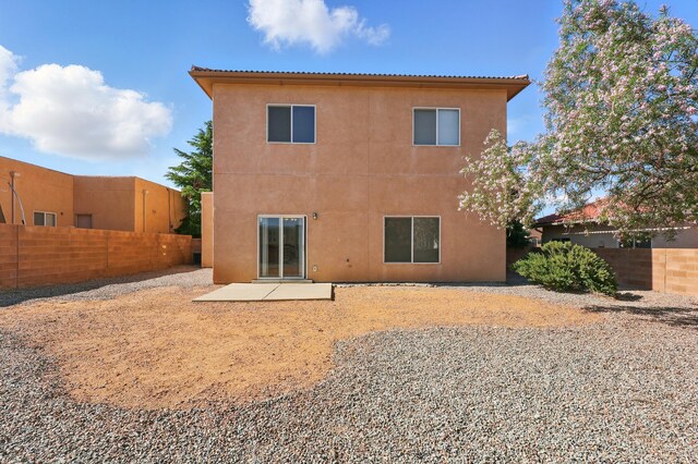 10016 Rio Canon Ave SW, Albuquerque, NM 87121 - rear view of house with stucco siding and a patio area