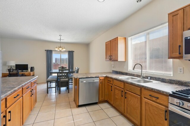 10016 Rio Canon Ave SW, Albuquerque, NM 87121 - kitchen with appliances with stainless steel finishes, a chandelier, light tile patterned floors, a peninsula, and pendant lighting