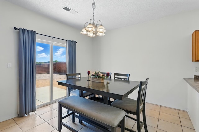 10016 Rio Canon Ave SW, Albuquerque, NM 87121 - dining area with a chandelier, light tile patterned floors, and a textured ceiling