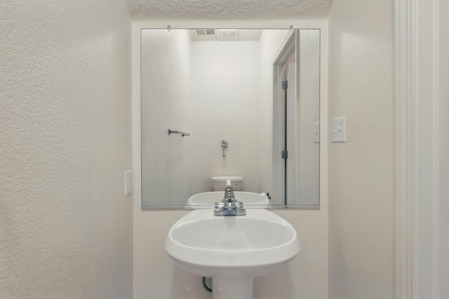 10016 Rio Canon Ave SW, Albuquerque, NM 87121 - half bathroom featuring a textured wall and a textured ceiling