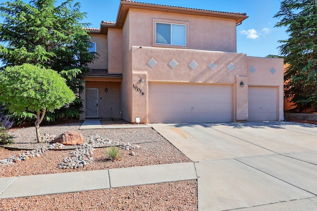 10016 Rio Canon Ave SW, Albuquerque, NM 87121 - view of front of house with stucco siding, concrete driveway, and a tiled roof