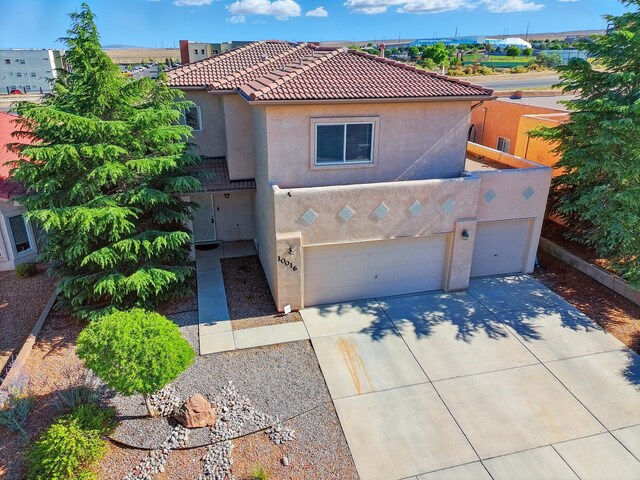 10016 Rio Canon Ave SW, Albuquerque, NM 87121 - mediterranean / spanish house with stucco siding, driveway, a tiled roof, and an attached garage