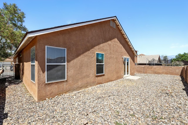 5940 Night Rose Ave NW, Albuquerque, NM 87114 - view of side of home featuring stucco siding and a fenced backyard