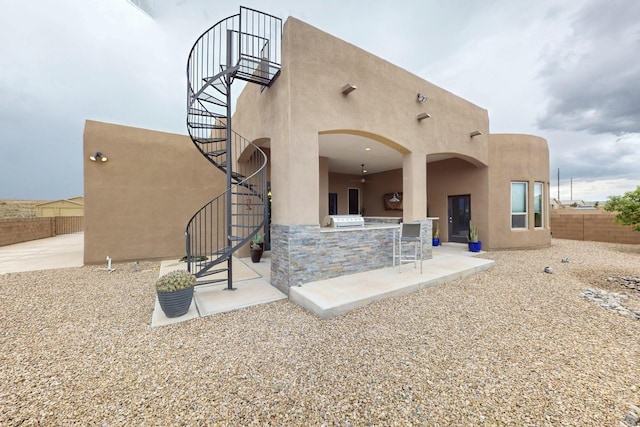 3220 Vatapa Rd NE, Rio Rancho, NM 87144 - back of property featuring stairway, stucco siding, exterior kitchen, and a patio