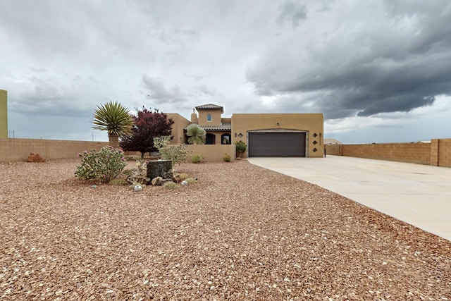 3220 Vatapa Rd NE, Rio Rancho, NM 87144 - pueblo-style house featuring concrete driveway, an attached garage, a tiled roof, and stucco siding