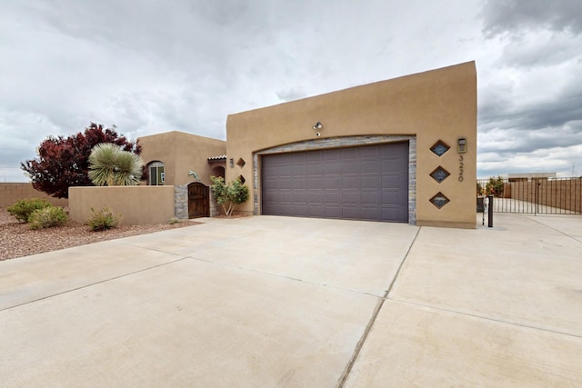 3220 Vatapa Rd NE, Rio Rancho, NM 87144 - adobe home featuring a gate, stucco siding, concrete driveway, and an attached garage