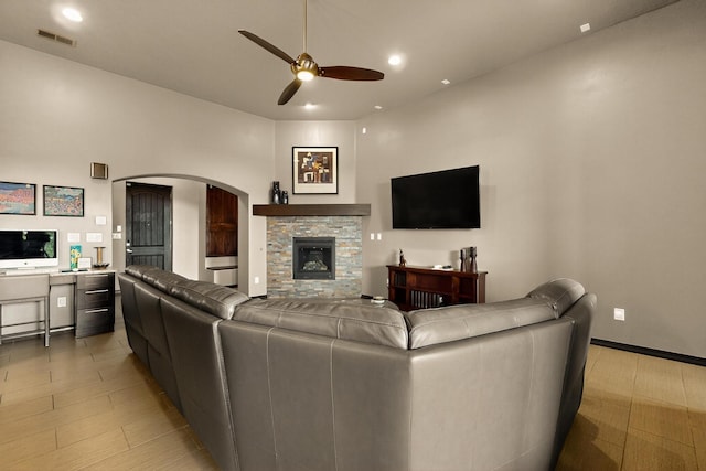 3220 Vatapa Rd NE, Rio Rancho, NM 87144 - living room with a ceiling fan, arched walkways, recessed lighting, and a stone fireplace