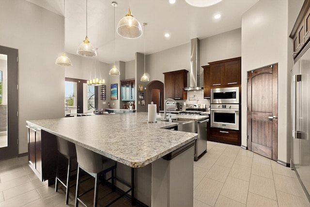 3220 Vatapa Rd NE, Rio Rancho, NM 87144 - kitchen featuring appliances with stainless steel finishes, a large island, a high ceiling, a chandelier, and tasteful backsplash