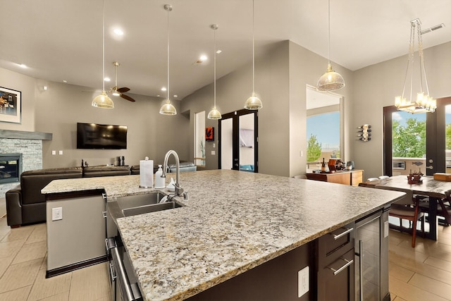 3220 Vatapa Rd NE, Rio Rancho, NM 87144 - kitchen with a sink, beverage cooler, open floor plan, an island with sink, and decorative light fixtures