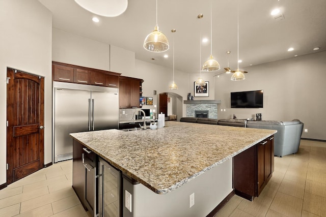 3220 Vatapa Rd NE, Rio Rancho, NM 87144 - kitchen featuring stainless steel built in refrigerator, wine cooler, a large island with sink, light stone counters, and pendant lighting