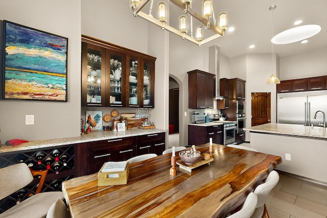 3220 Vatapa Rd NE, Rio Rancho, NM 87144 - dining space with arched walkways, a high ceiling, a chandelier, and recessed lighting
