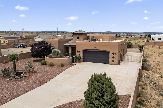 3220 Vatapa Rd NE, Rio Rancho, NM 87144 - pueblo-style home featuring stucco siding, a gate, concrete driveway, a garage, and a tile roof