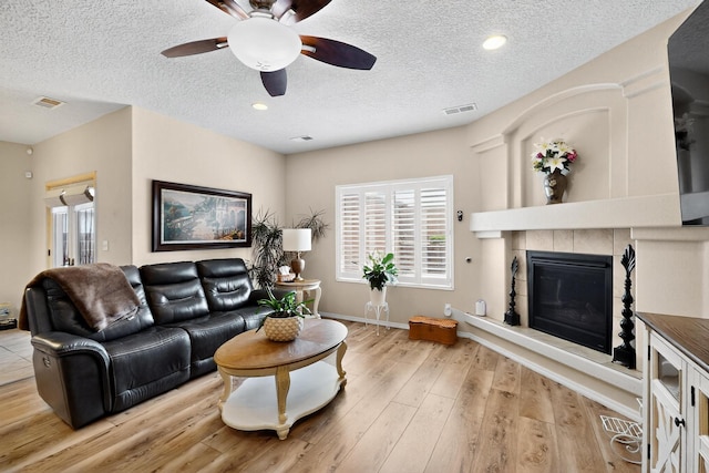 1720 Summer Breeze Dr NW, Albuquerque, NM 87120 - living area featuring ceiling fan, wood finished floors, a textured ceiling, a tile fireplace, and recessed lighting