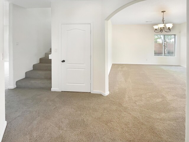 10909 Estribo St NW, Albuquerque, NM 87114 - unfurnished room featuring carpet, arched walkways, a chandelier, and stairs