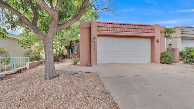 11041 Academy Ridge Rd NE, Albuquerque, NM 87111 - pueblo-style home featuring a tiled roof, stucco siding, concrete driveway, and an attached garage