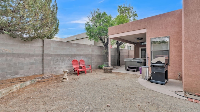 11041 Academy Ridge Rd NE, Albuquerque, NM 87111 - fenced backyard featuring a hot tub, ceiling fan, and a patio