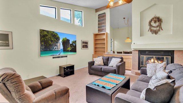 11041 Academy Ridge Rd NE, Albuquerque, NM 87111 - living area featuring carpet floors, a high ceiling, a tiled fireplace, a ceiling fan, and baseboards